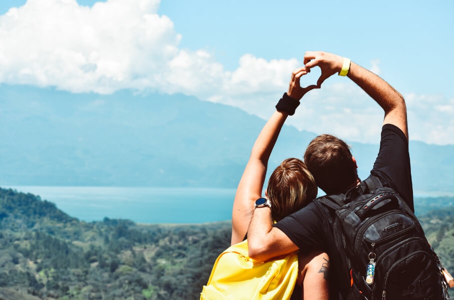 Couple sitting on a mountain looking at a lake